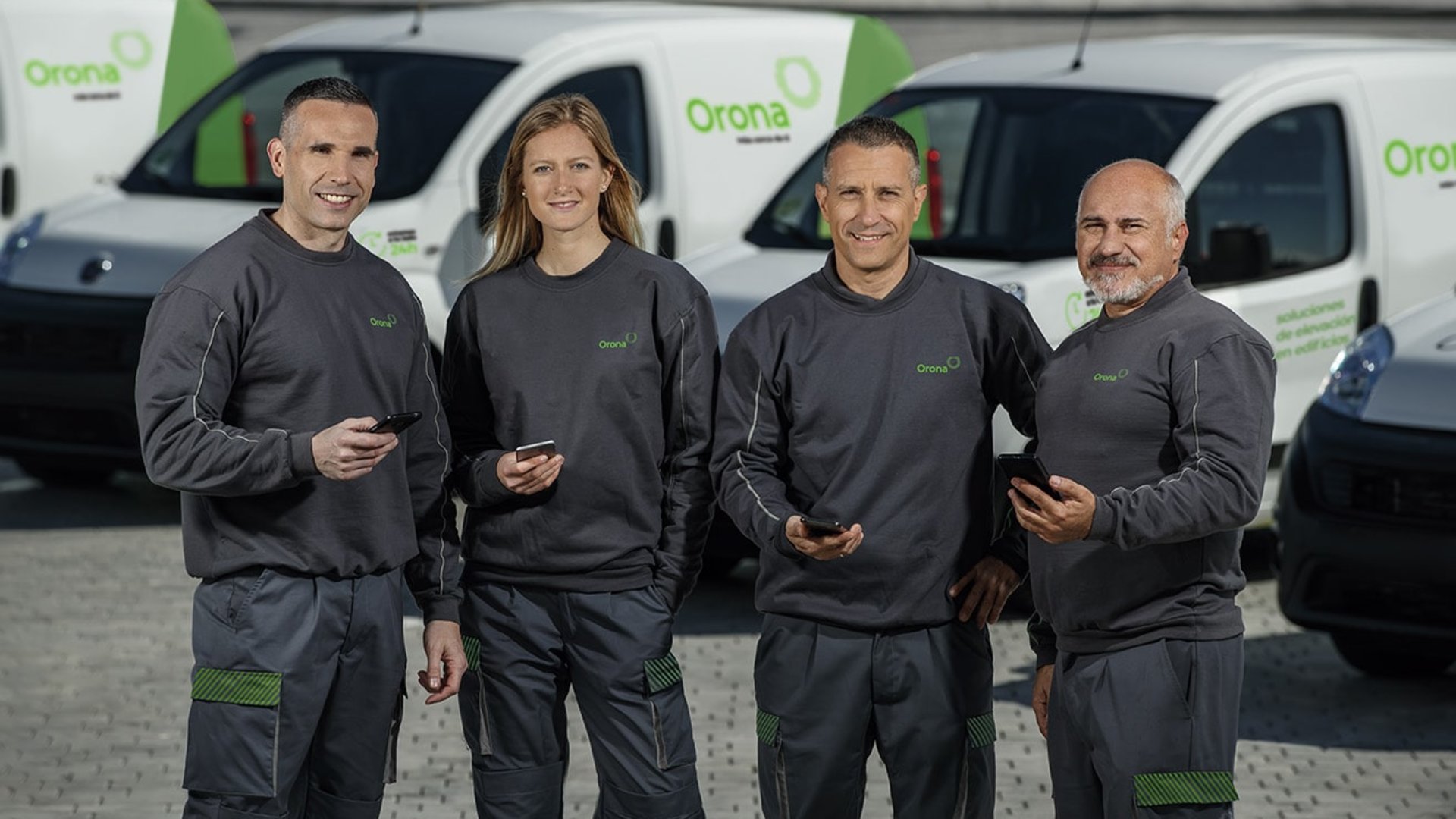 Team of men and women with cars in the background