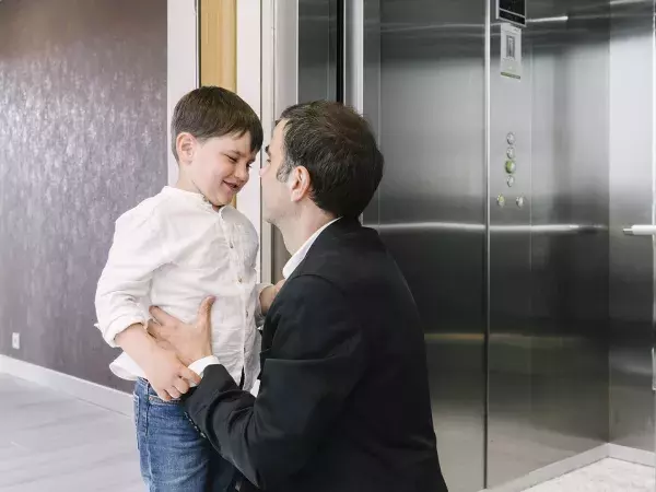 Padre e hijo en el rellano junto al ascensor